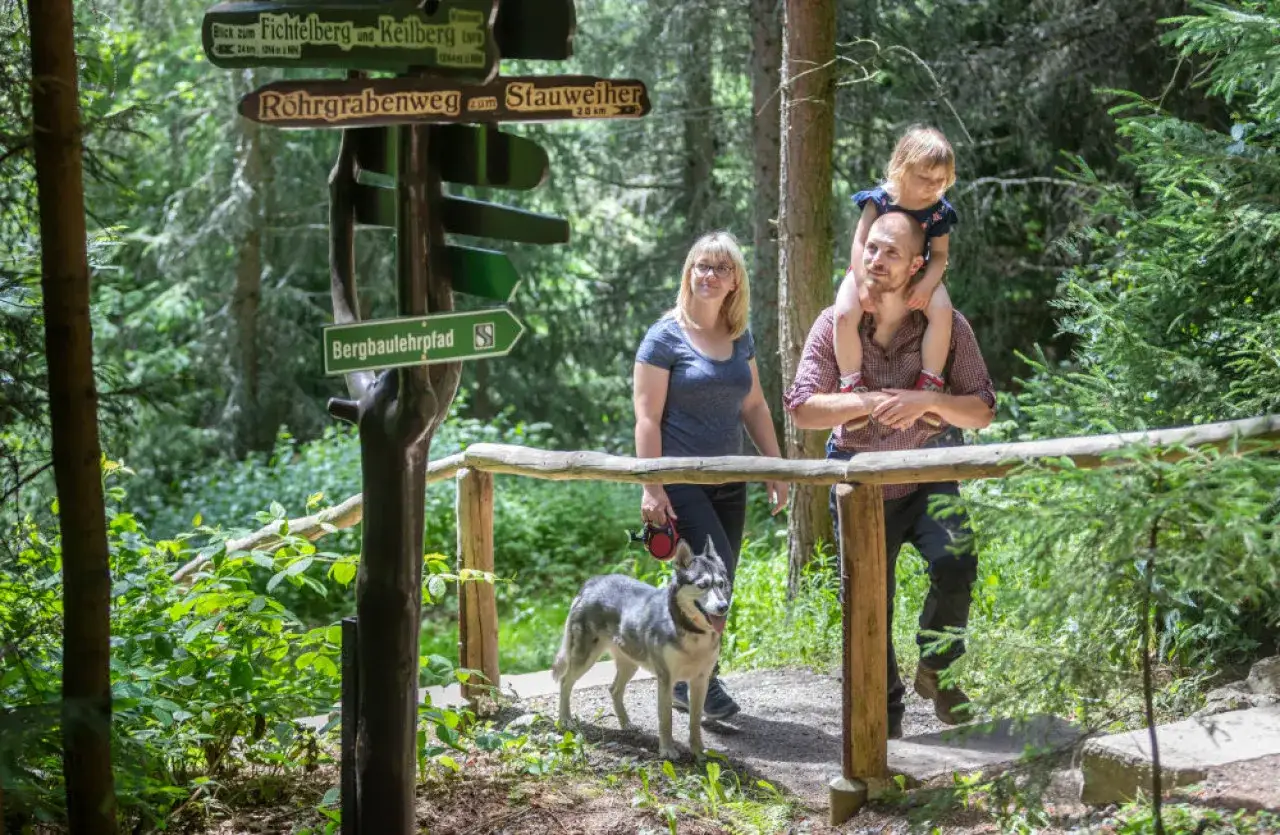 Familie mit Hund auf einem Wanderweg, bereit f&uuml;r die herbstferien 2026.