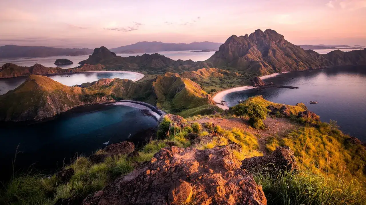 Atemberaubende Aussicht auf die Inseln Komodo, Indonesien. Ein Traum für jede Reiseroute Indonesien, mit grünen Hügeln, weißen Sandstränden und türkisfarbenem Wasser.