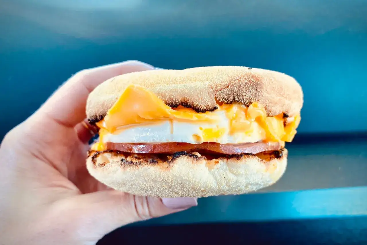 McMuffin z jajkiem, serem i szynką, idealny na szybkie śniadanie.