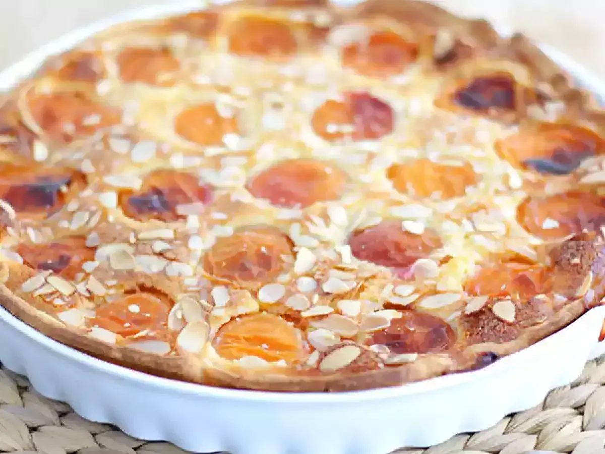 Tarta casera con trozos de albaricoque y almendras laminadas. Un delicioso postre que recuerda a la mermelada de albaricoque.