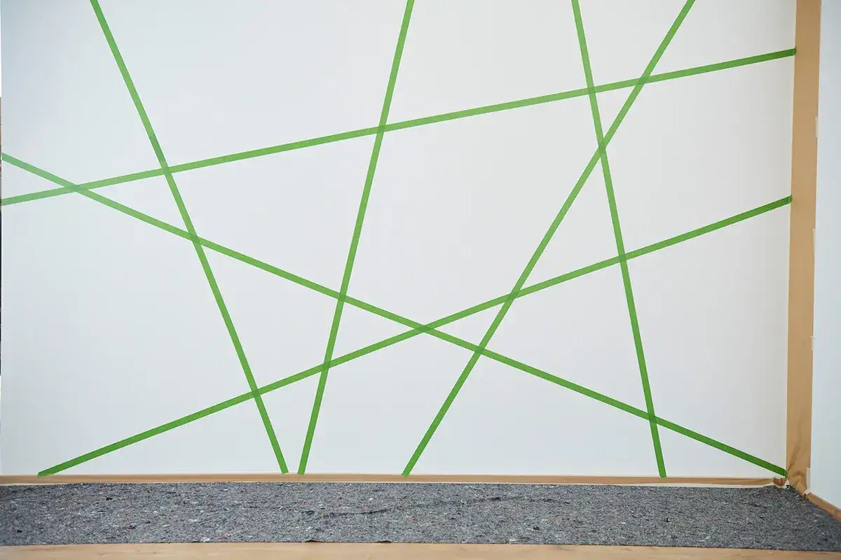 Wand streichen: Muster abkleben mit gr&uuml;nen Klebestreifen f&uuml;r kreative Ideen.