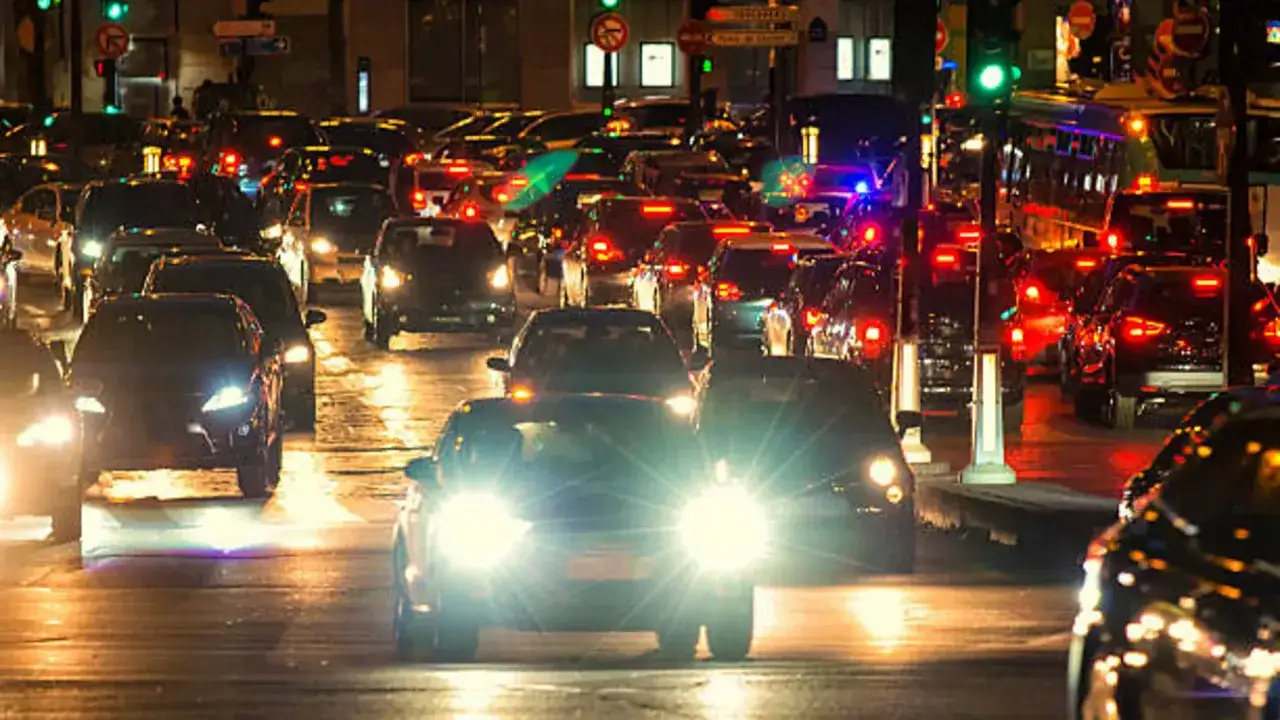 Tr&aacute;fico nocturno con luces de coches y el alumbrado de carretera creando un ambiente urbano.