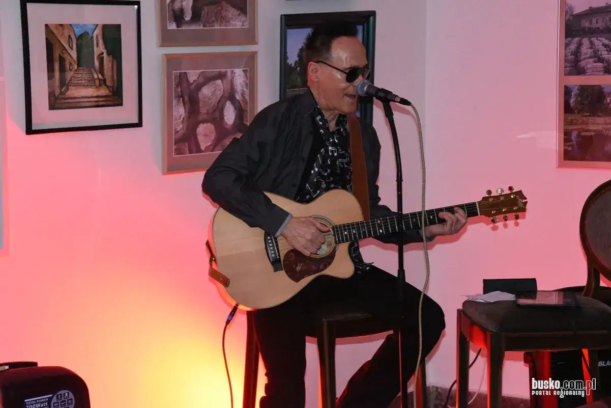 Jerzy Grunwald gra na gitarze akustycznej, wykonując swoje utwory.