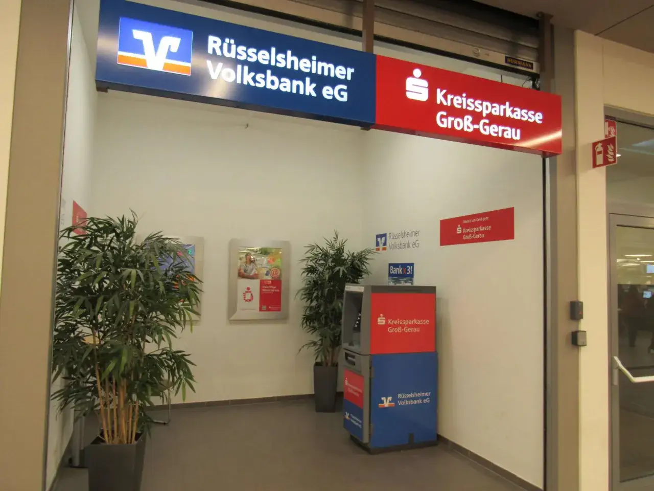 Zwei Bankautomaten stehen nebeneinander: einer der Rüsselsheimer Volksbank eG und einer der Kreissparkasse Groß-Gerau.