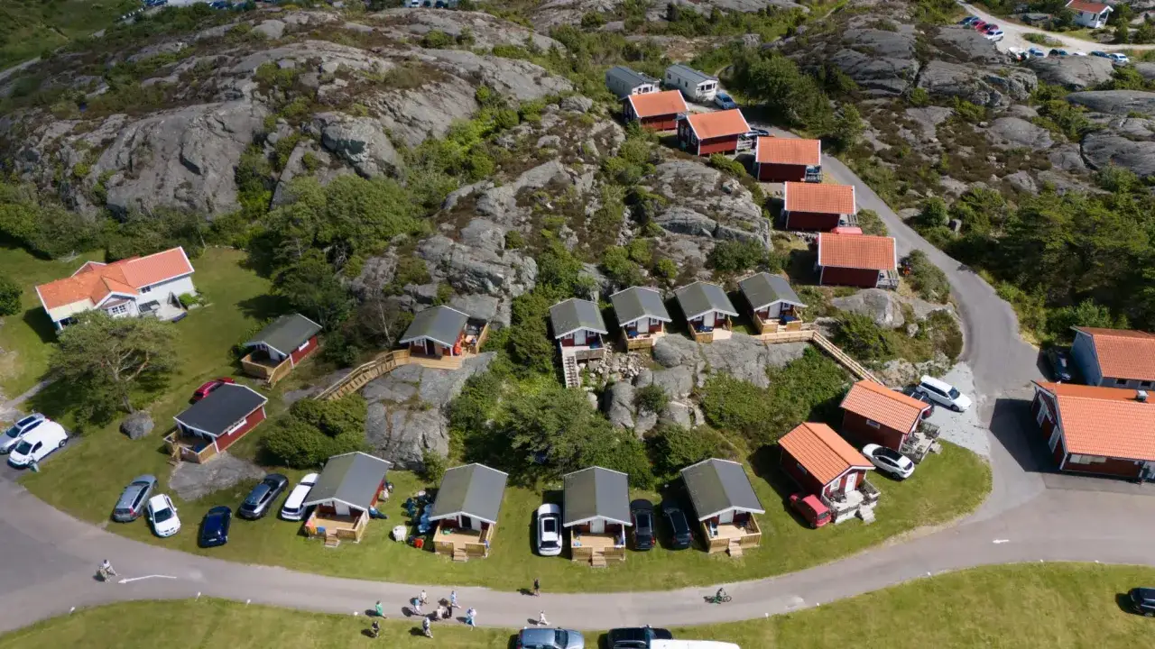 En idyllisk camping på Orust med röda stugor och klippor.