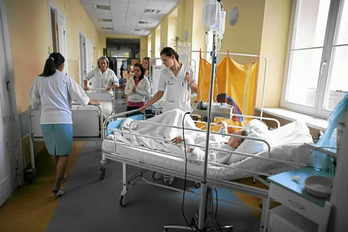 Szpitalny korytarz, pielęgniarki przy łóżkach pacjentów. Ile przerwy na 12 godzin pracy?
