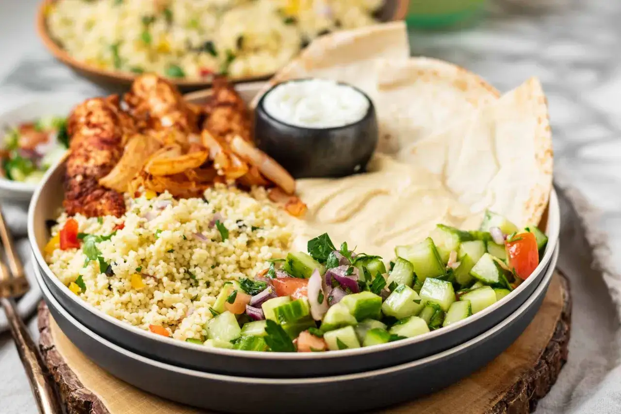 En härlig shawarma-tallrik med kyckling, couscous, hummus, grönsaker och pitabröd. Ett perfekt shawarma recept för en god middag.
