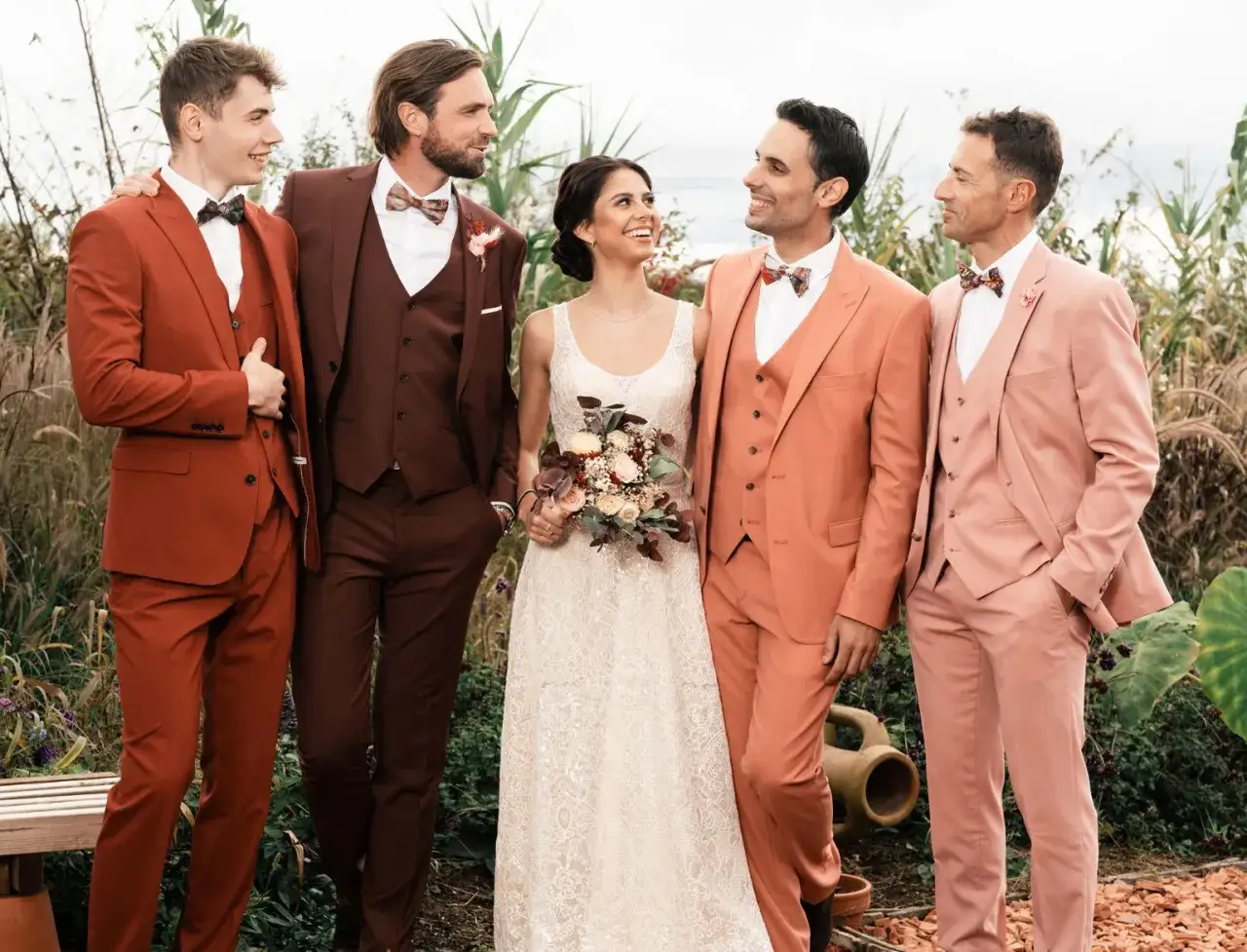 Mari&eacute;s et t&eacute;moins arborent des costumes de mariage aux couleurs audacieuses : rouille, bordeaux, corail et rose poudr&eacute;.