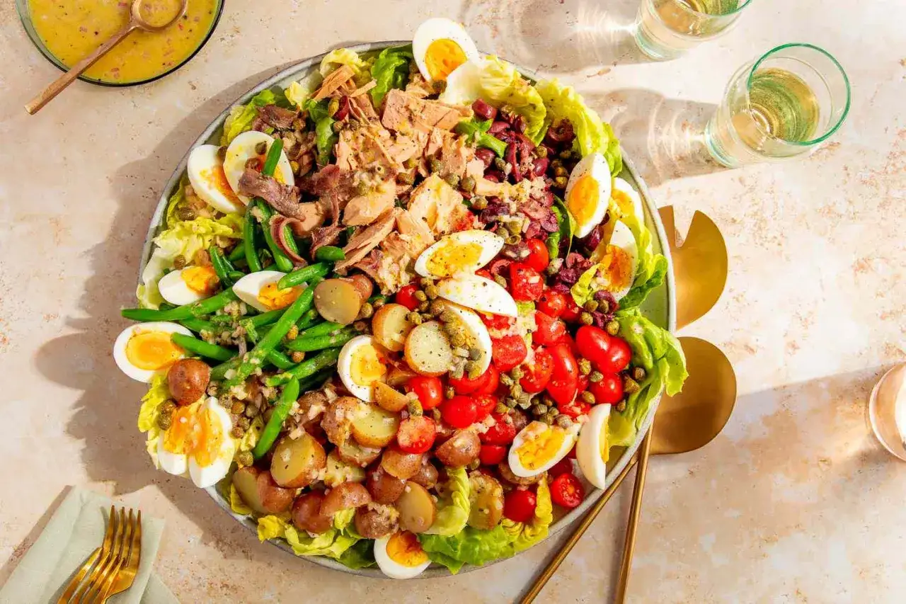 Ein bunter Salat Niçoise mit Thunfisch, Ei, Kartoffeln, grünen Bohnen und Tomaten. Perfekt für ein leichtes Mittagessen oder als Teil eines sommerlichen Buffets.
