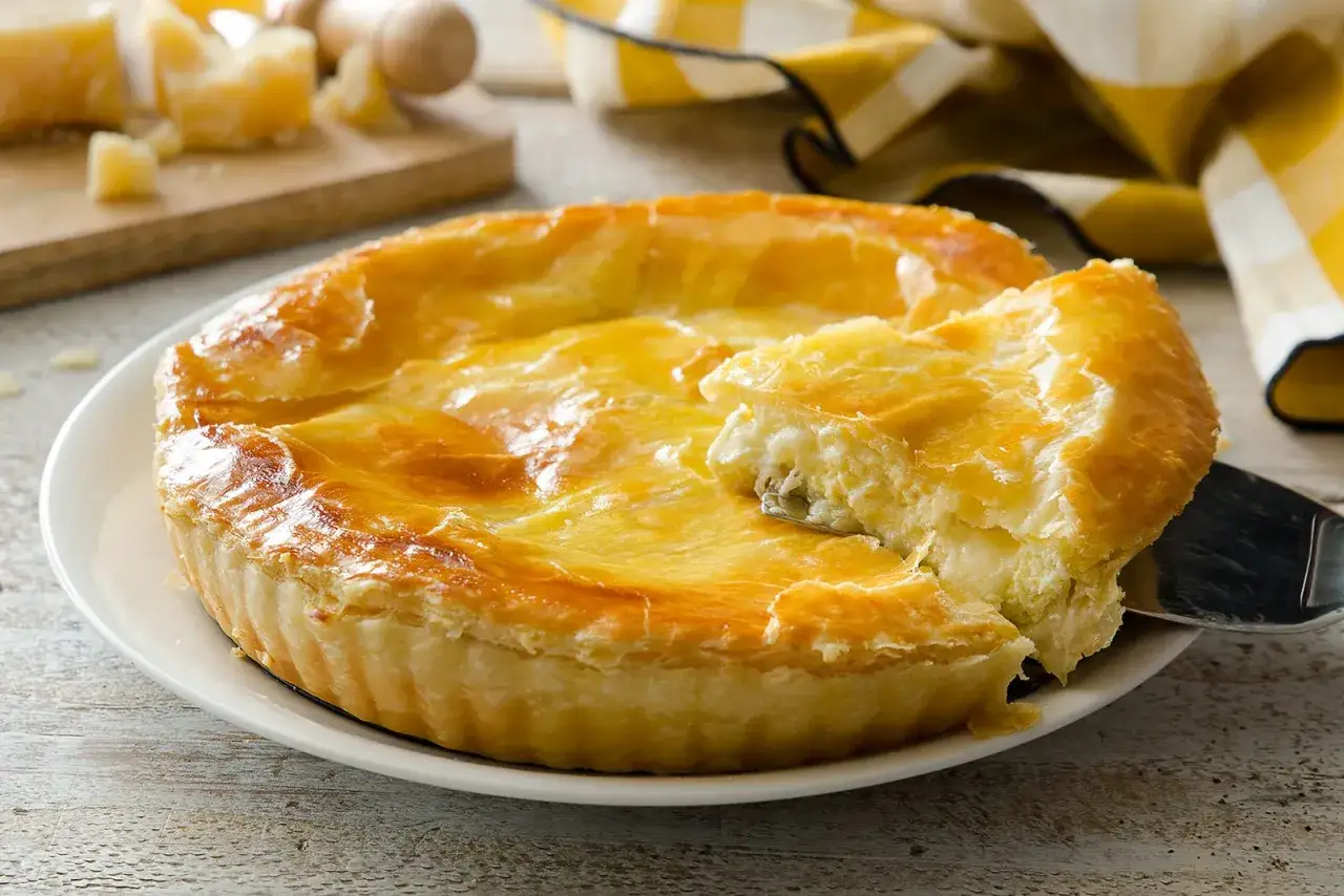 Torta salata dorata, perfetta per le tue ricette con formaggio grattugiato. Un morso cremoso che invita a scoprire il sapore.
