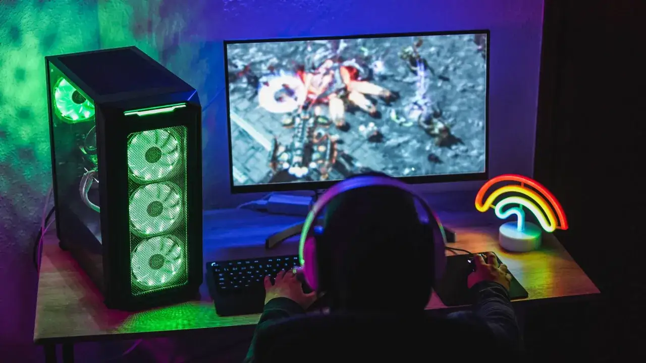 Spieler spielt ein Strategiespiel auf dem PC, beleuchtet vom grünen Licht des Towers und der **Blizzard App** auf dem Monitor.