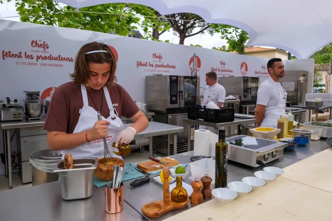 Jeune chef prépare une sauce pour la journée internationale des cuisiniers. L'événement célèbre les producteurs et le savoir-faire régional.