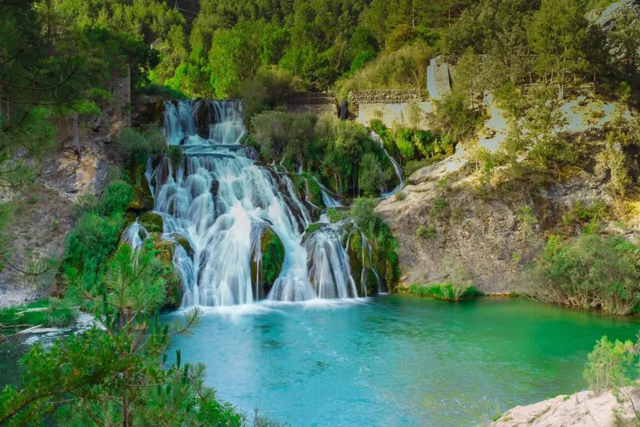 Cascada espectacular en el **r&iacute;o Guadalajara**, rodeada de vegetaci&oacute;n exuberante y rocas. El agua turquesa forma un remanso sereno.