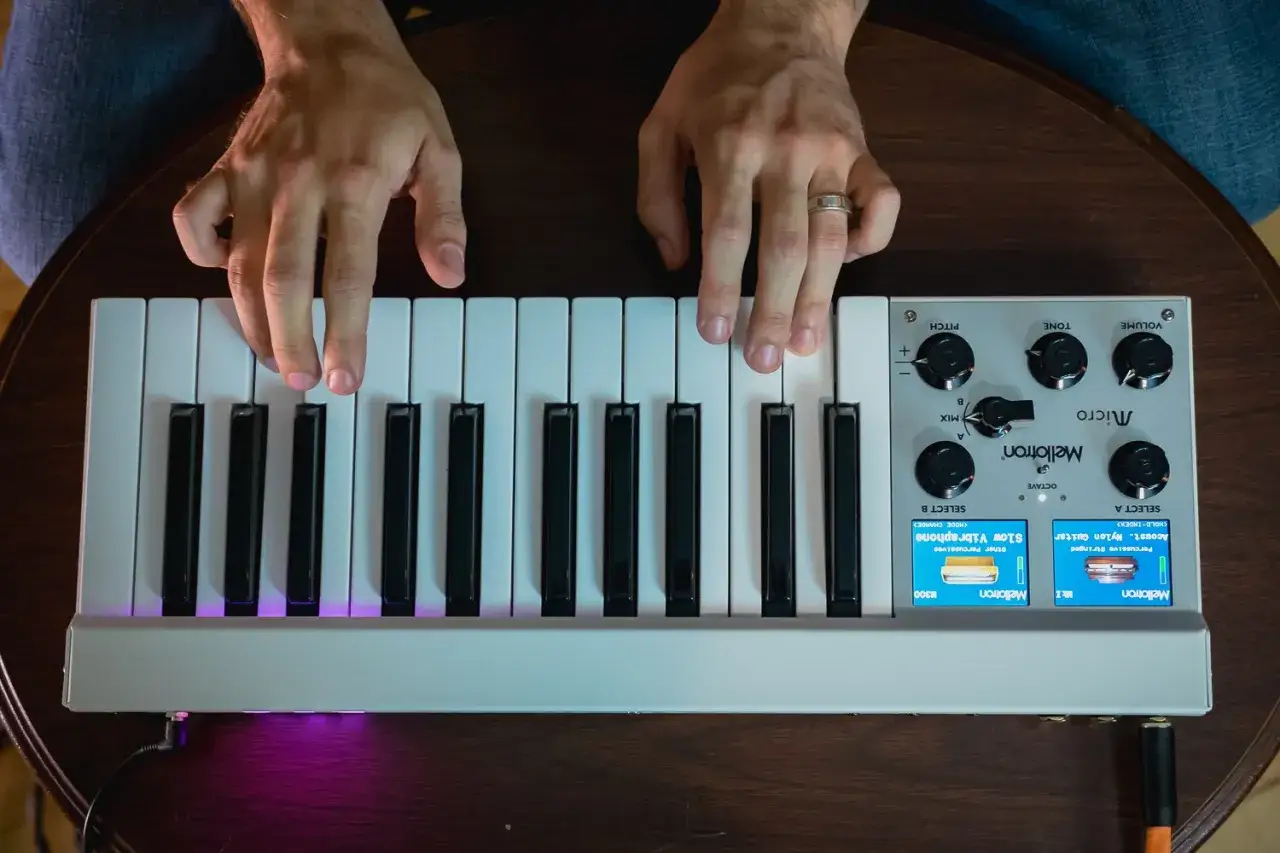 H&auml;nde spielen auf einem Mellotron-Instrument. Die Tasten leuchten lila.
