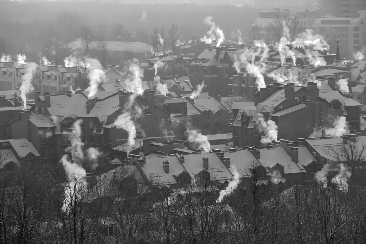 Dym z kominów nad osiedlem zimą. Jak zapobiegać smogowi? Brainly podpowiada rozwiązania.