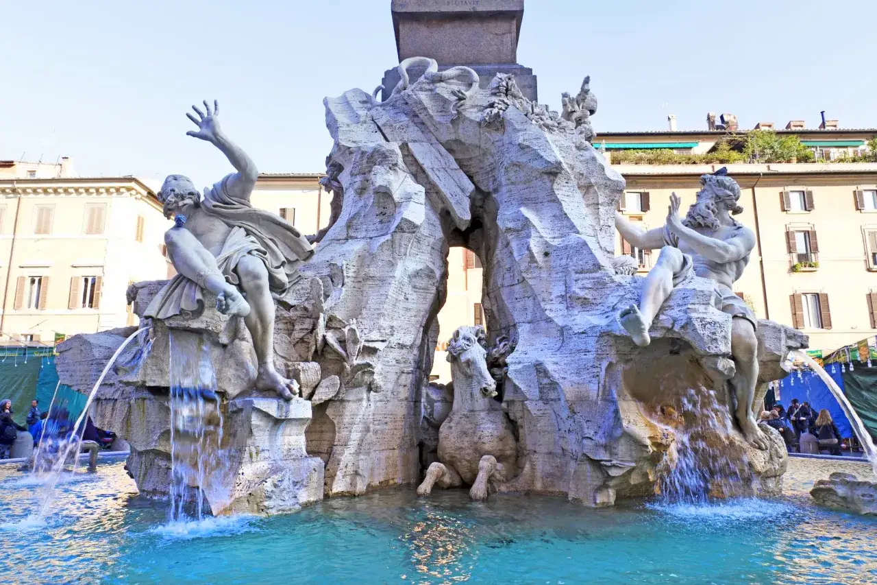 La Fontana dei Quattro Fiumi, con le sue maestose statue e l'acqua che scorre, domina la piazza.