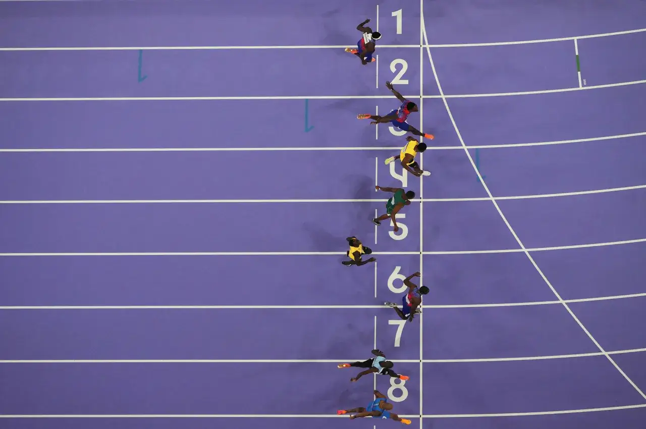 Biegacze na bieżni, walka o rekord świata 100 m. Widok z góry na torach 1-8.