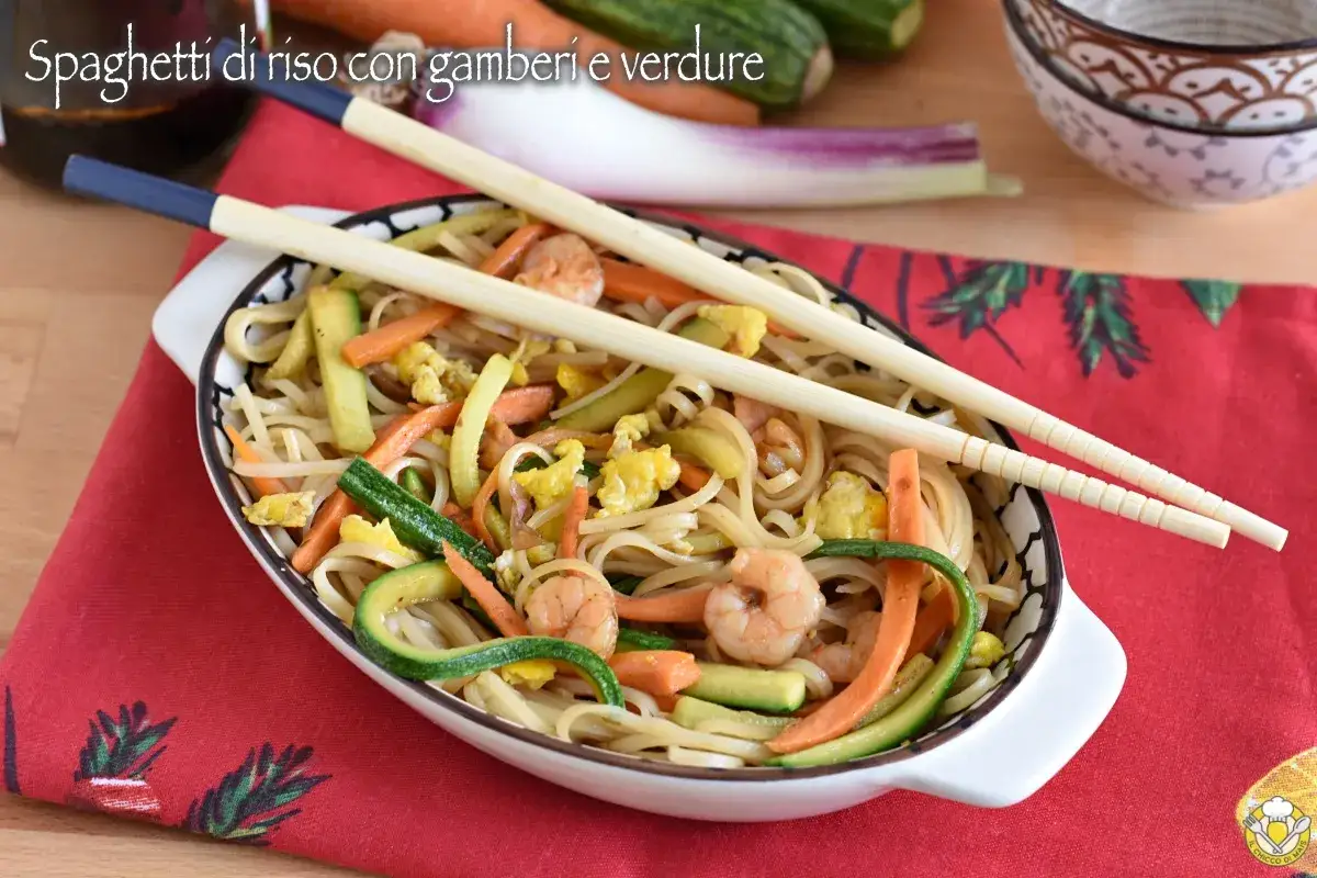 Spaghetti di riso con gamberi e verdure colorate, un piatto invitante e saporito.