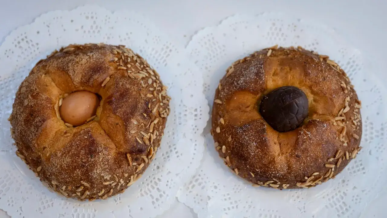 Dos monas de Pascua catalanas, una con huevo cocido y otra con un huevo de chocolate, decoradas con almendras y az&uacute;car.
