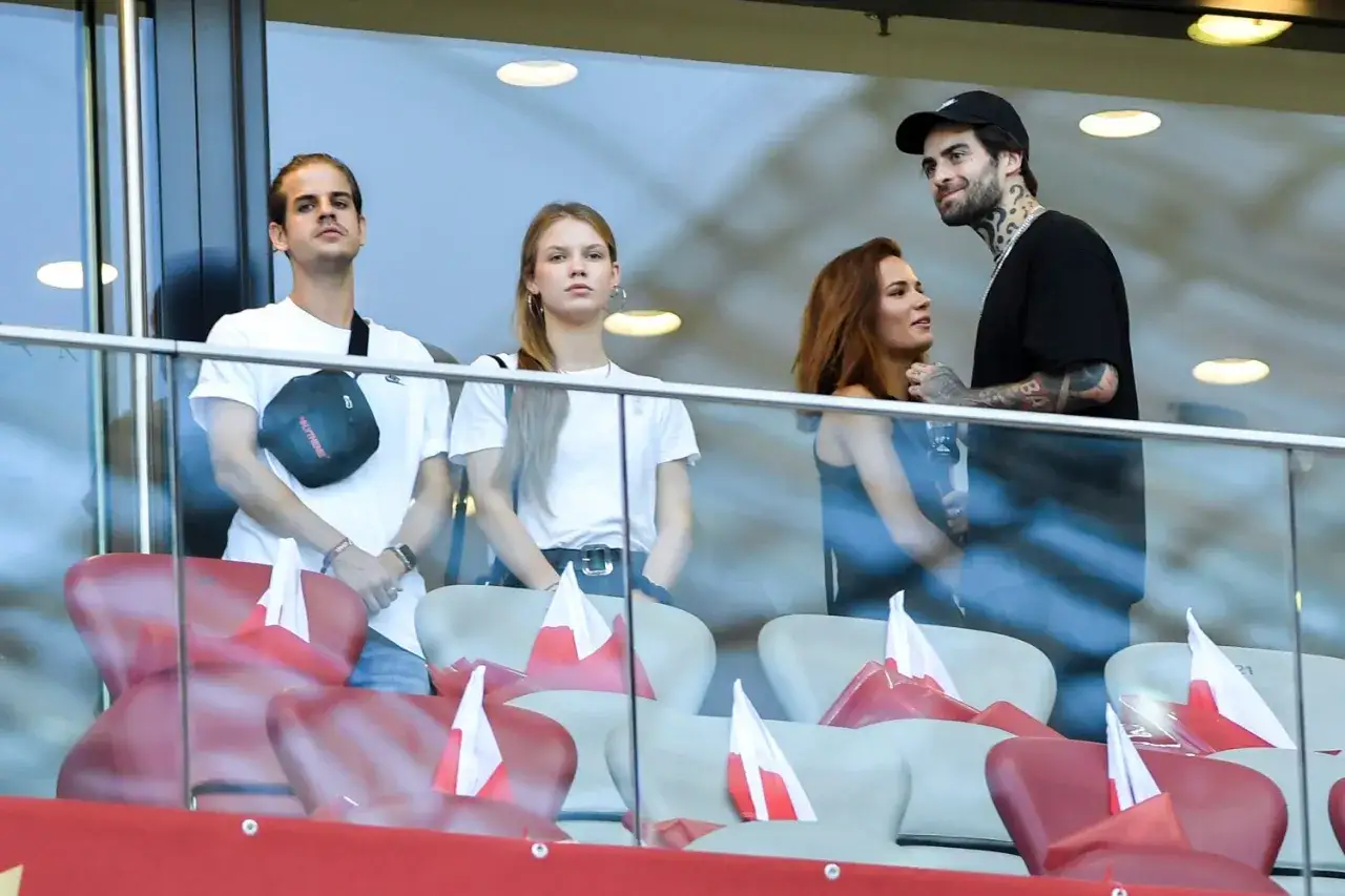 Natalia Szroeder i Quebo kibicują na trybunach, otoczeni polskimi flagami.