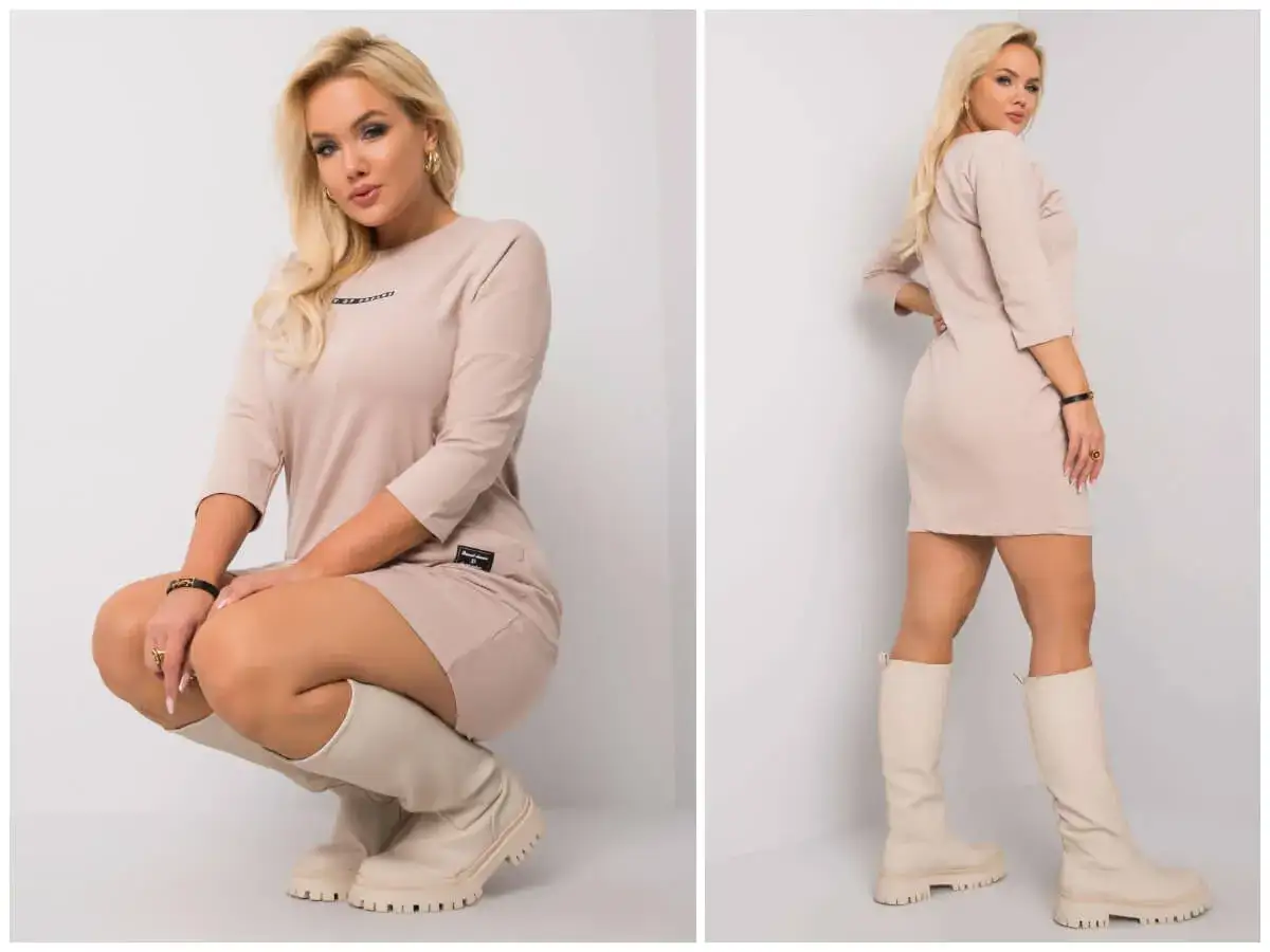 Kobieta plus size w beżowej sukience i kozakach. To znaczy, że piękno nie zna rozmiaru.