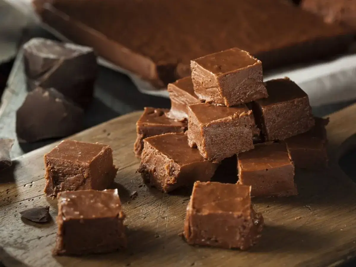 Chokladfudge i kuber på en träskärbräda. Perfekt för ett enkelt fudge recept.