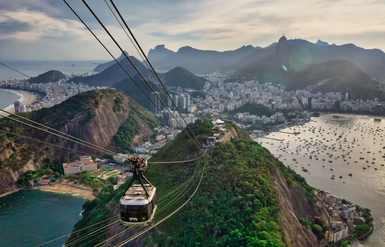 Seilbahnfahrt &uuml;ber Rio de Janeiro mit Blick auf die Stadt, den Strand und den Zuckerhut.