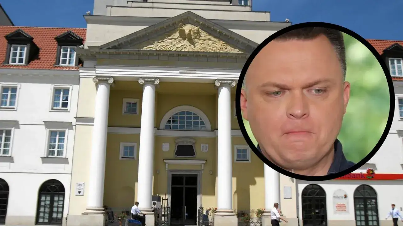 Szymon Hołownia na tle budynku z kolumnami i banku.