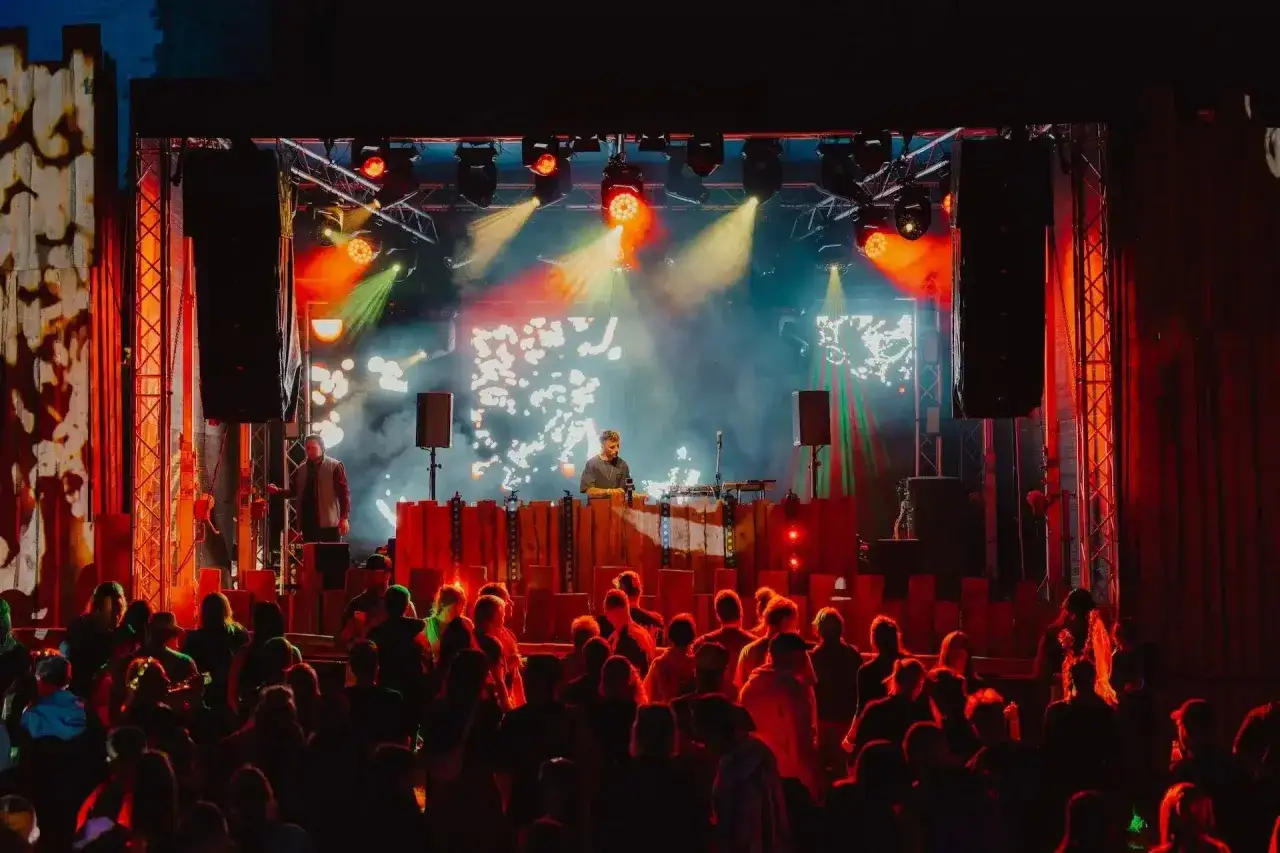 DJ legt bei G&ouml;rlitz Konzerten auf, die Menge tanzt im Scheinwerferlicht.