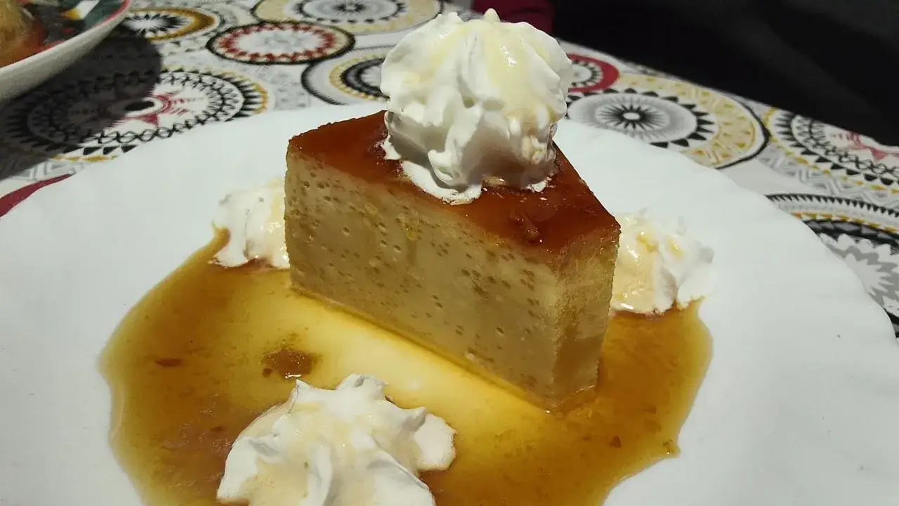 Delicioso flan de huevo casero, cubierto con crema batida y bañado en caramelo líquido. Una tentación para cualquier paladar.