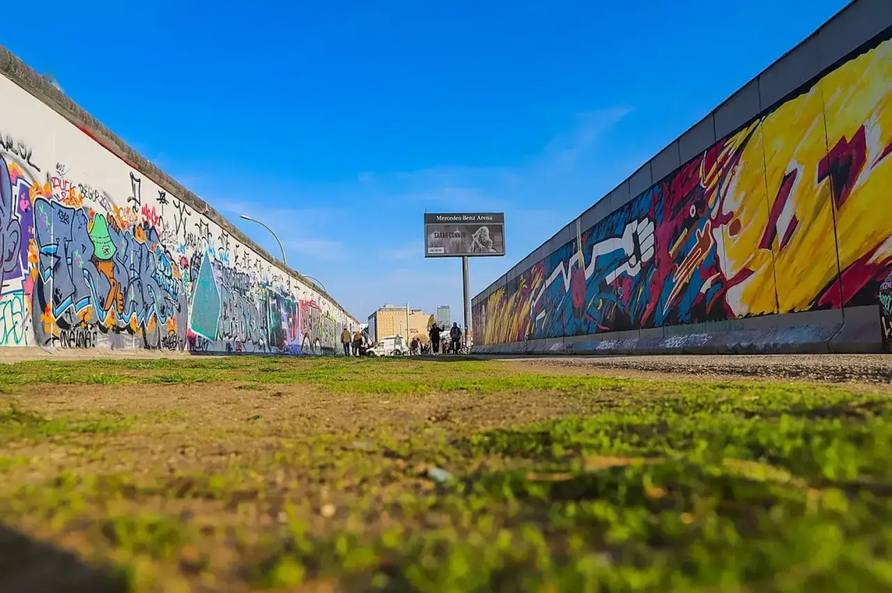 Kolorowe murale na East Side Gallery w Berlinie, symbol wolności i sztuki.