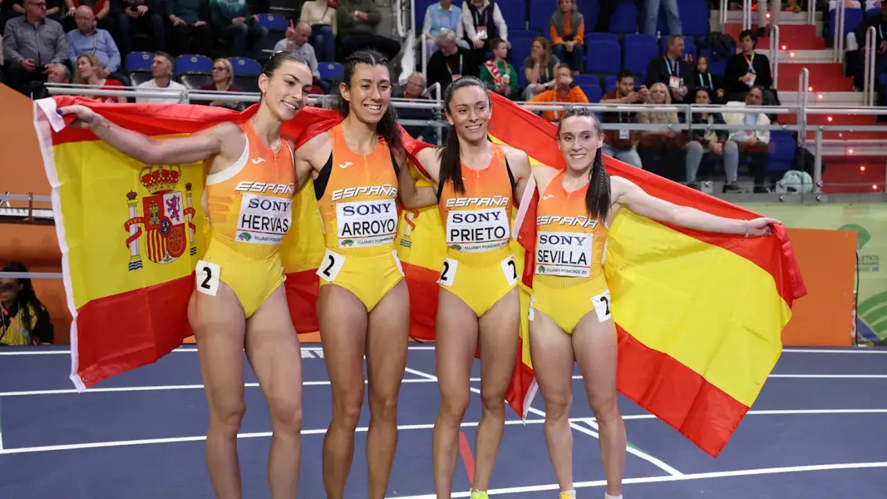 Cuatro atletas españolas celebran con la bandera de España. El atletismo femenino español brilla en la competición.