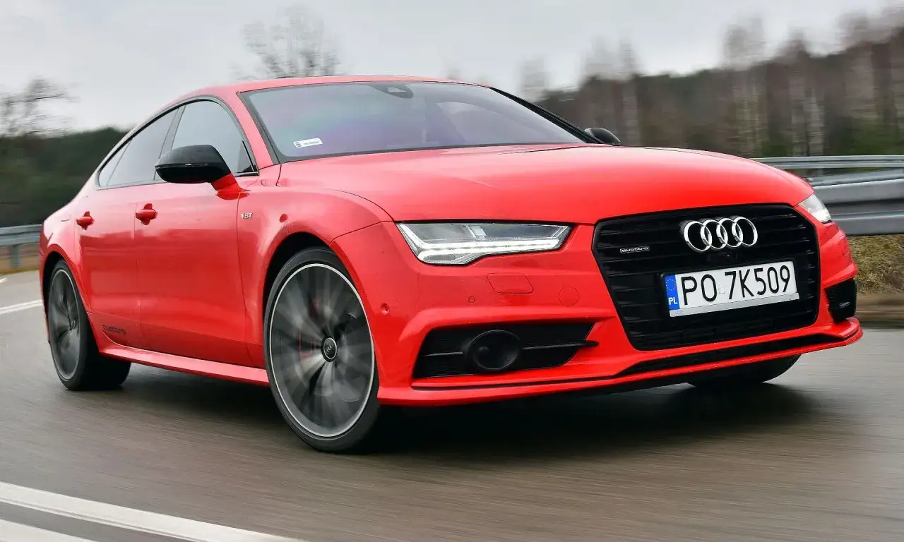 Czerwone Audi A7 na drodze, z widocznymi detalami karoserii i felg. Potężne audi a7 silniki zapewniają dynamikę.