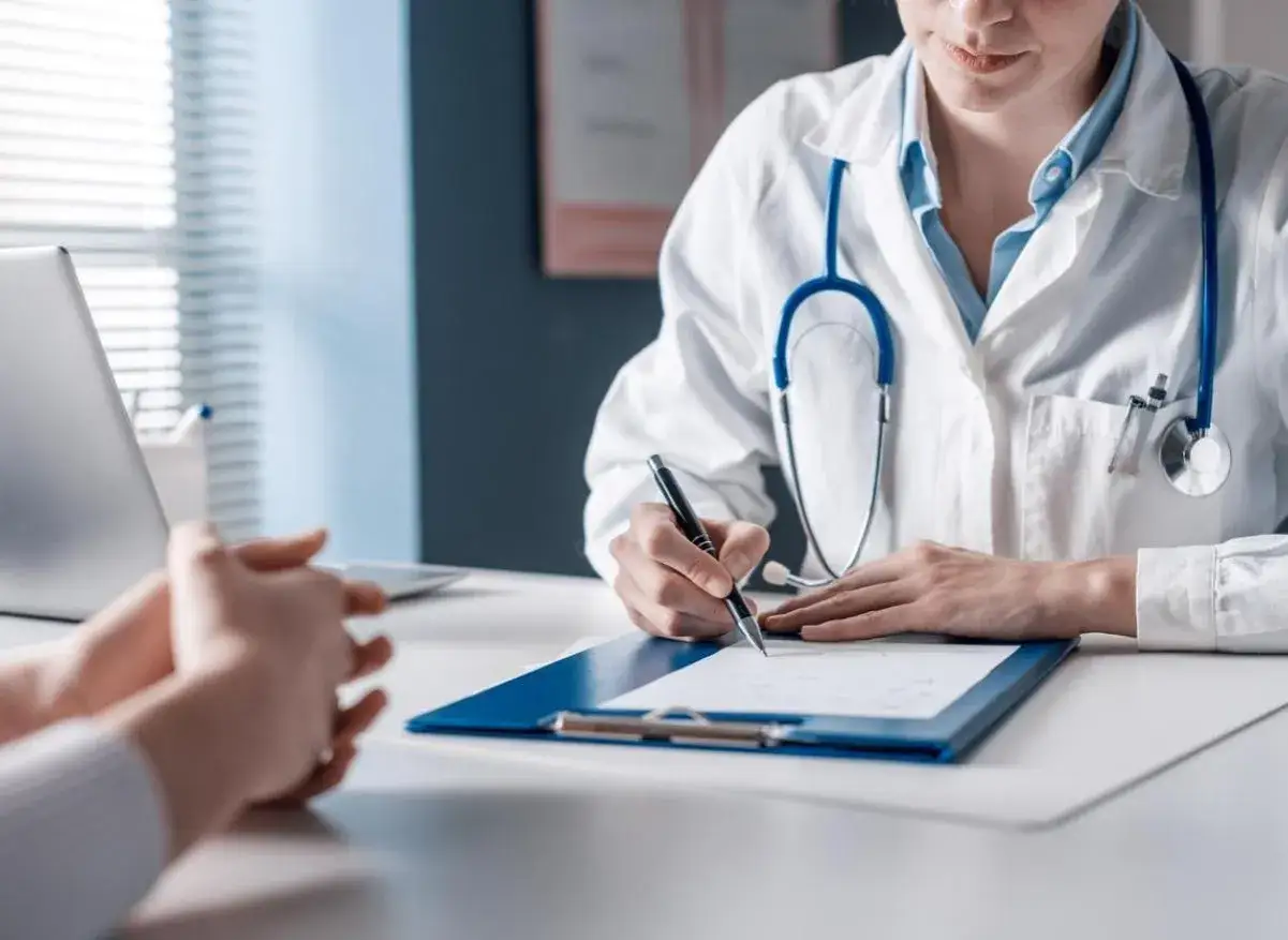 Un m&eacute;decin du travail &eacute;value la situation d'un patient souffrant de burn-out, prenant des notes pour documenter son r&ocirc;le essentiel dans la gestion de cette pathologie.