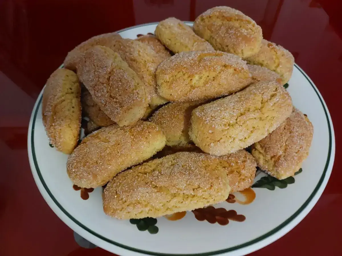 Un piatto colmo di biscotti della nonna, dorati e cosparsi di zucchero. Un dolce profumo di casa.