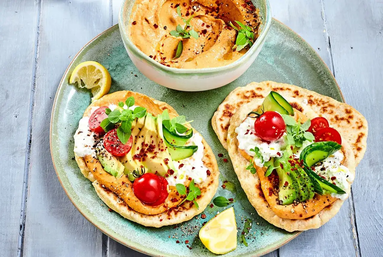Hummus dip mit Fladenbrot, belegt mit Avocado, Tomaten, Gurke und Kr&auml;utern. Ein leichter Genuss!