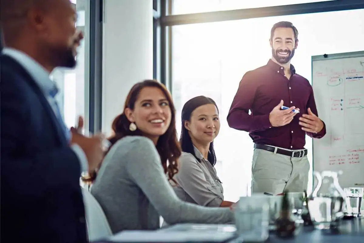 A trainer leads an engaging session on emotional intelligence in the workplace, with attentive colleagues listening and smiling.