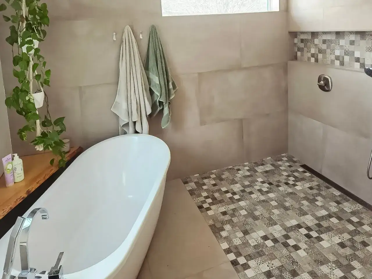 Salle de bain moderne en cours de construction, avec baignoire &icirc;lot, carrelage au sol et mur de douche d&eacute;coratif.