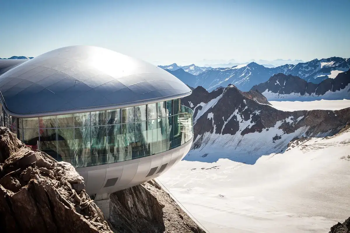 Moderne Bergstation am Pitztaler Gletscher mit Panoramablick auf schneebedeckte Gipfel.