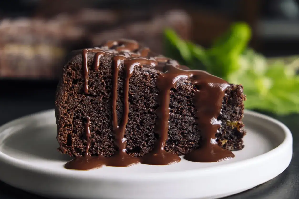 Wilgotne ciasto brownie z płynną czekoladą, polane obficie gorącym sosem czekoladowym, wygląda apetycznie.