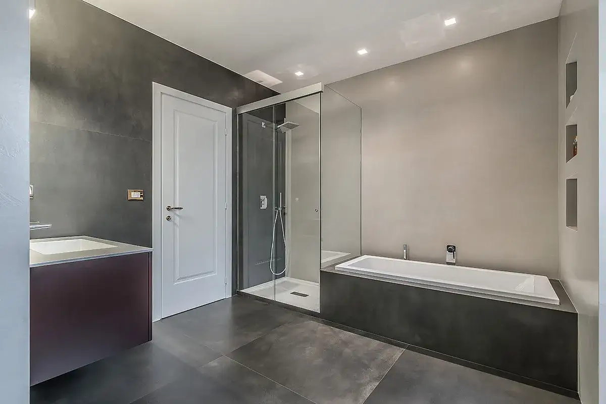 Bagno moderno con doccia a nicchia in vetro, vasca e lavabo. L'altezza della nicchia doccia è ben integrata nel design.