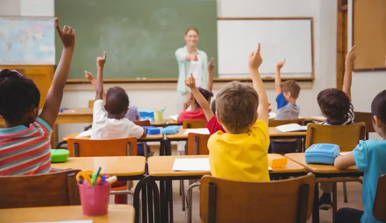 Schüler melden sich im Unterricht, um die Frage zu beantworten, welchen Abschluss man nach der Grundschule hat.