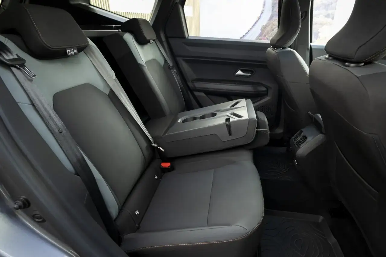 Interni Dacia Bigster: sedili posteriori in tessuto grigio e nero, bracciolo centrale ribaltabile con portabicchieri.