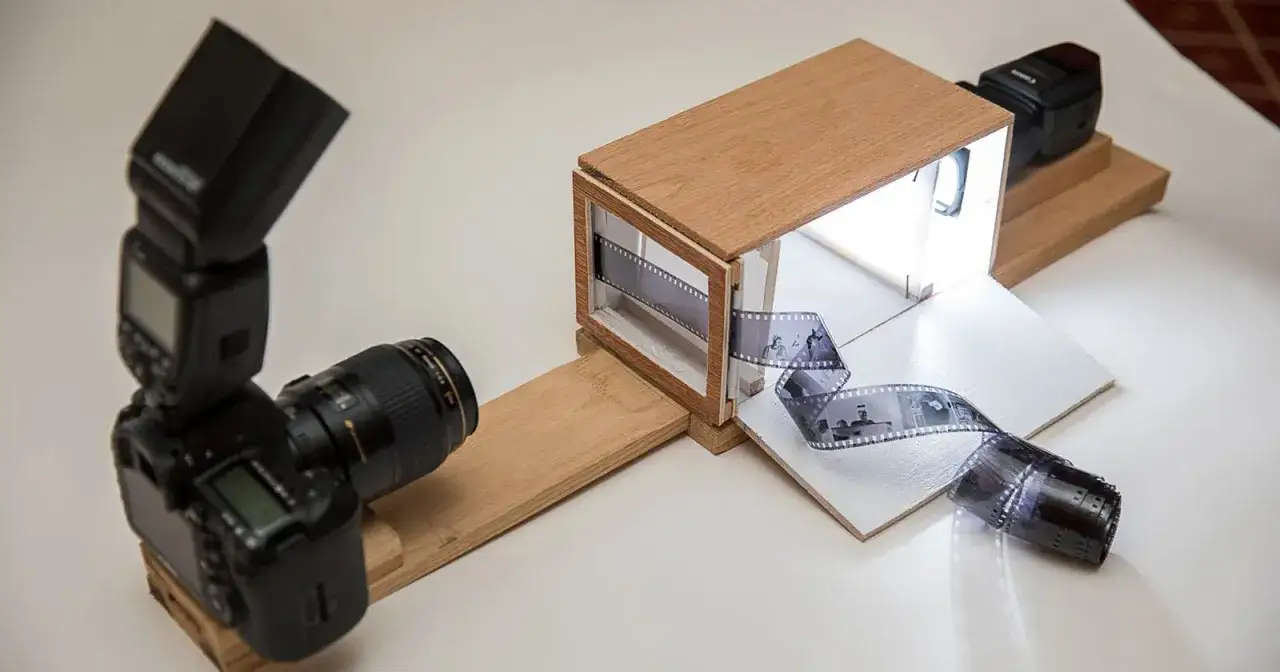 En hemmagjord ljusl&aring;da f&ouml;r att digitalisera gamla analog kamera bilder. En kamera med blixt &auml;r redo att fotografera filmremsor.