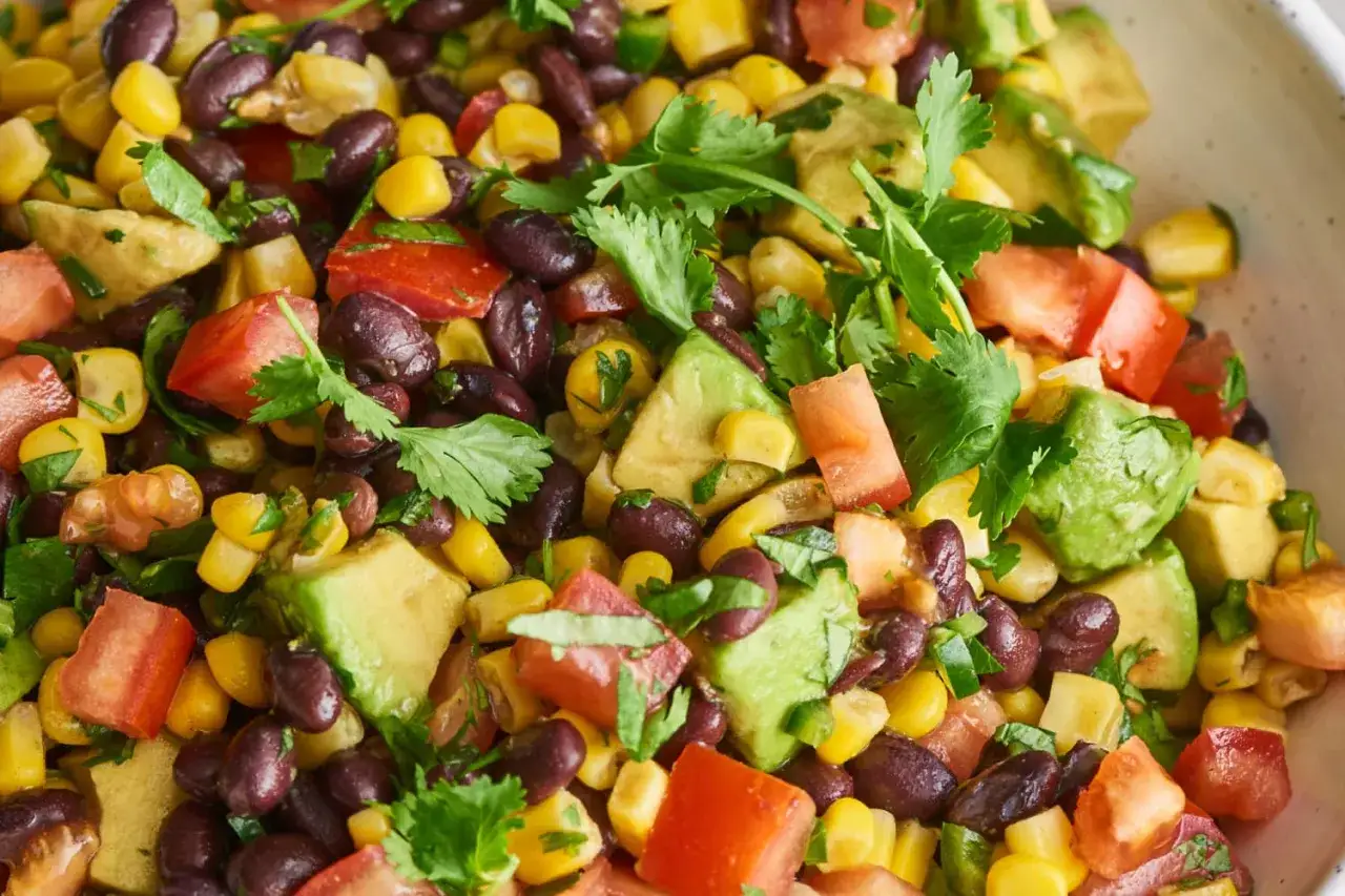 Frischer schwarze bohnen salat mit Mais, Avocado und Tomaten, garniert mit Koriander.