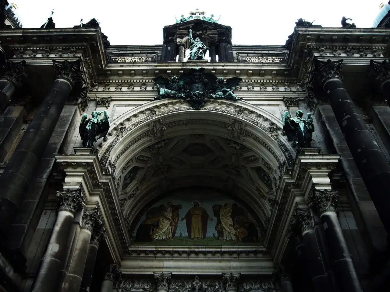 Monumentalna fasada katedry widziana z dołu, podkreślająca jej wielkość. Perspektywa w fotografii uwydatnia detale architektoniczne i rzeźby aniołów.