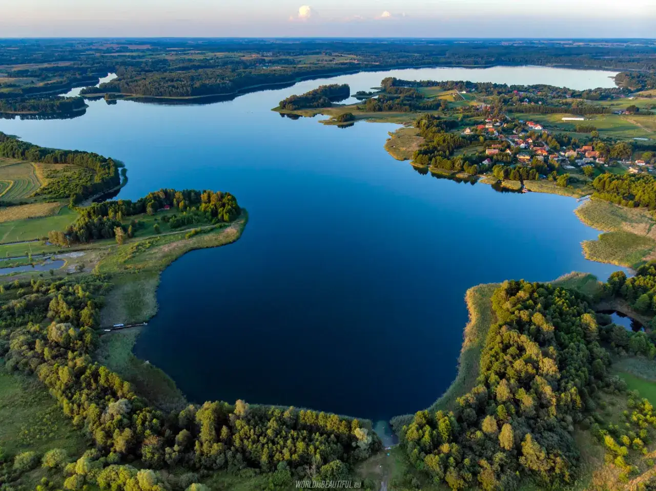 Widok z lotu ptaka na rozległe jeziora i lasy na Mazurach. Trudno policzyć, ile jest jezior na Mazurach, ale ten krajobraz pokazuje ich piękno.