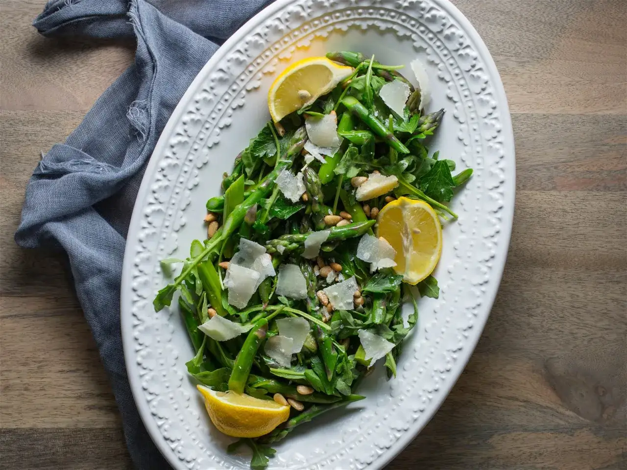 Frischer Spargelsalat mit Zitrone, Pinienkernen und Parmesan &ndash; ein wahrer weltbester Spargelsalat auf einem ovalen Teller.