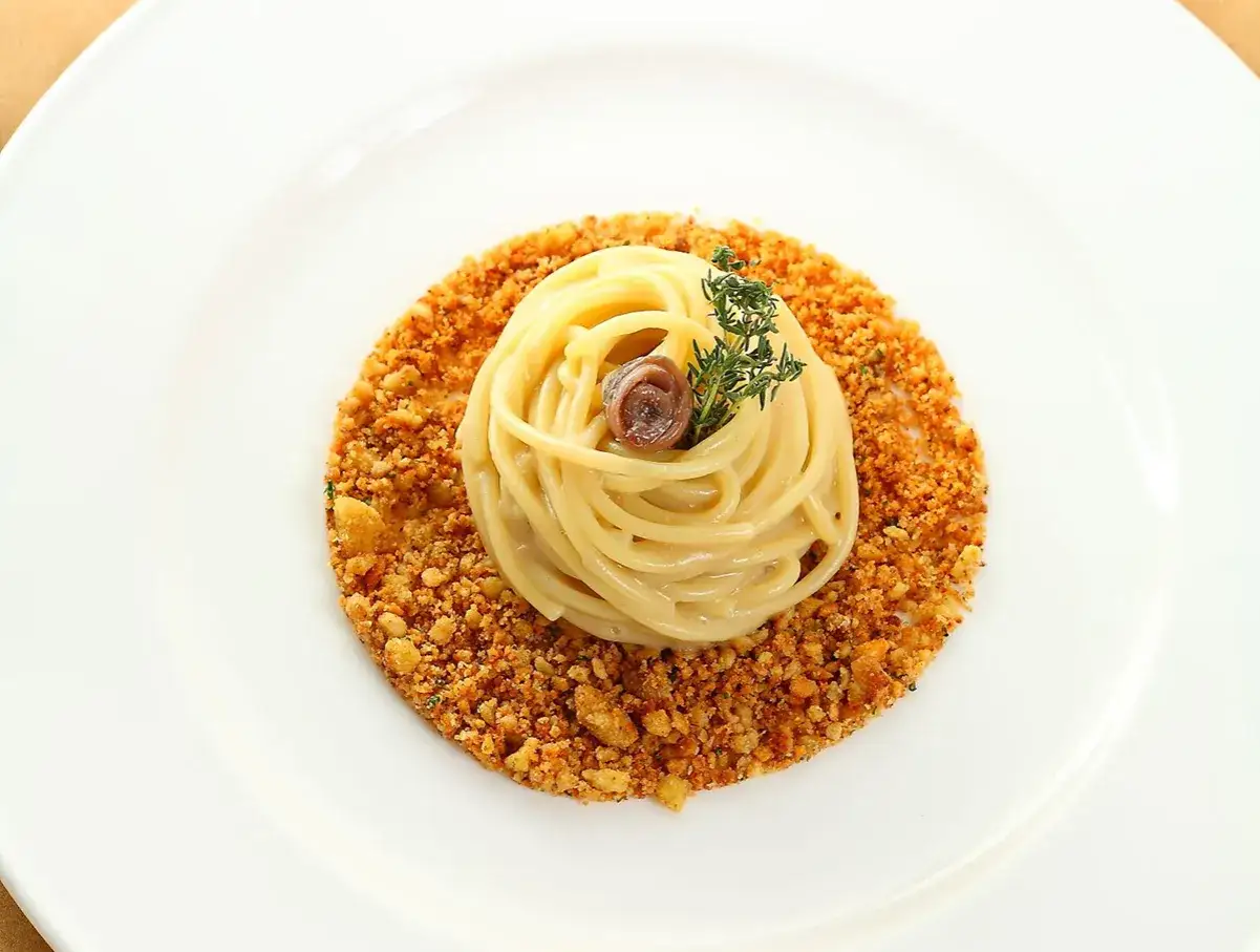 Spaghetti con burro e alici, guarniti con timo e croccante pangrattato. Un piatto semplice ma gustoso.