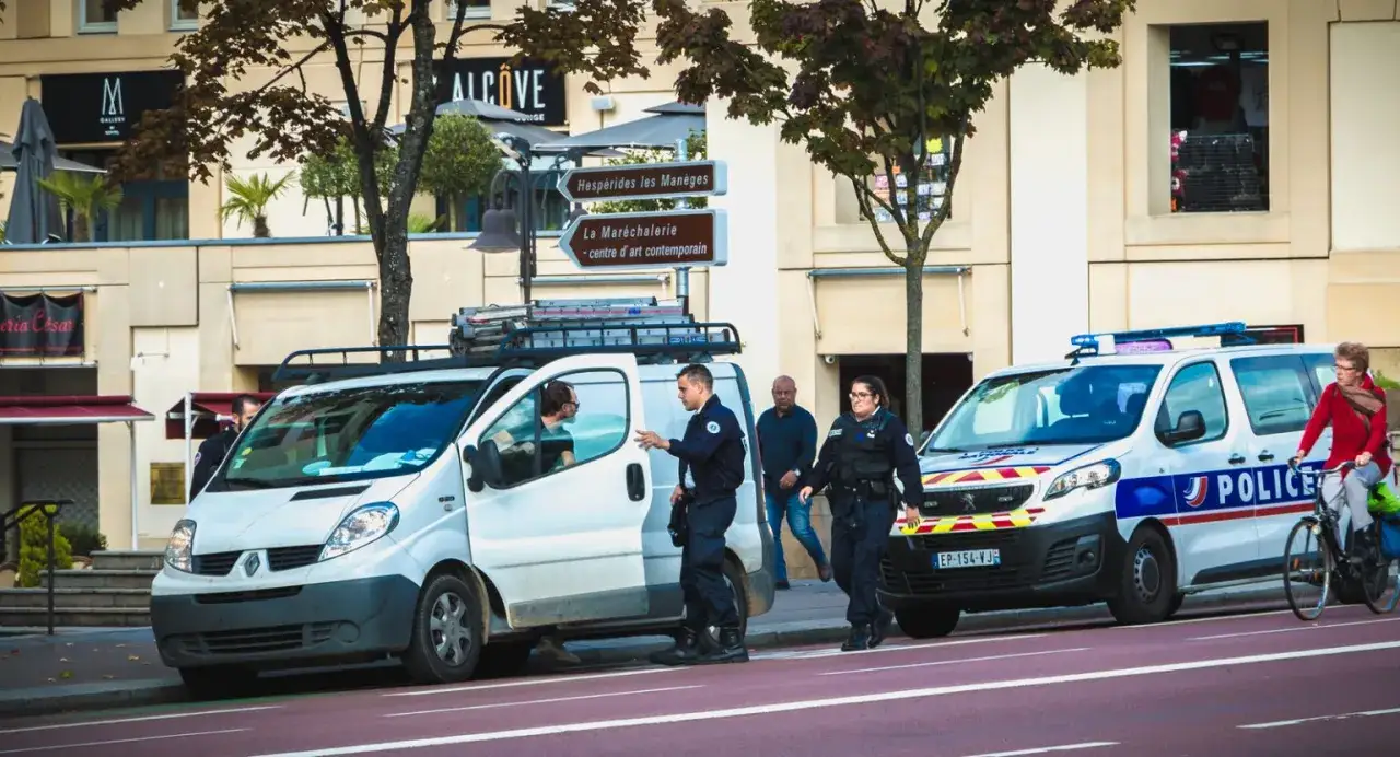 Policjanci w akcji, czy we Francji jest bezpiecznie? Widać radiowozy i funkcjonariuszy, co sugeruje obecność służb porządkowych.